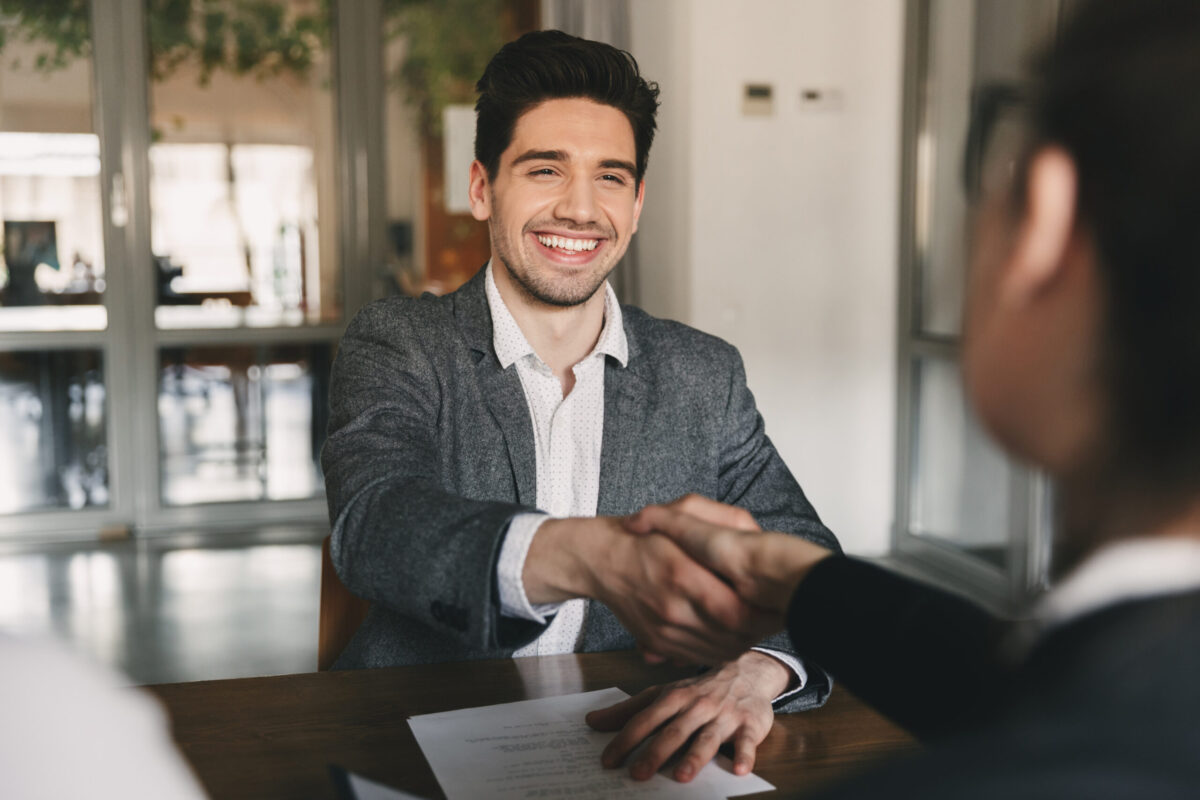 happy man shaking hands with recruited employee