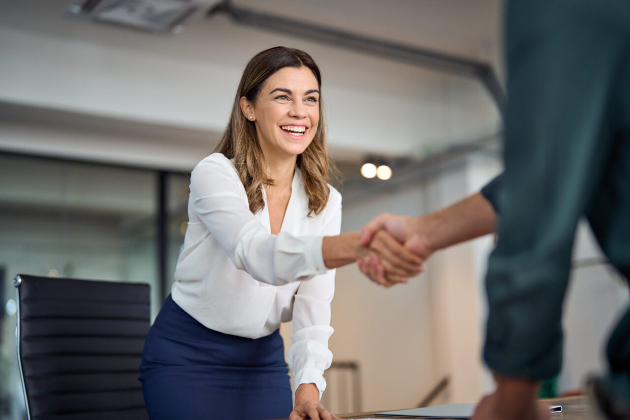 Businesswoman shaking hands with a client in an office